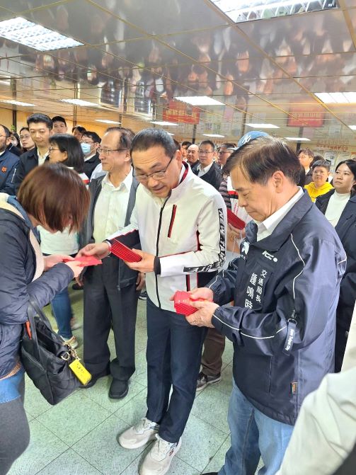 《圖說》侯友宜市長發放福袋給公車駕駛長,右一交通局長鍾鳴時。〈交通局提供〉