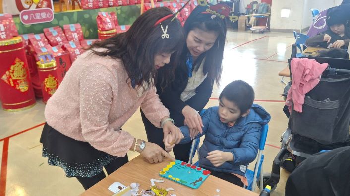 《圖說》院生阿忠(右)和志工惠真(左1)與秋香(中)一起創作相框DIY。〈社會局提供〉