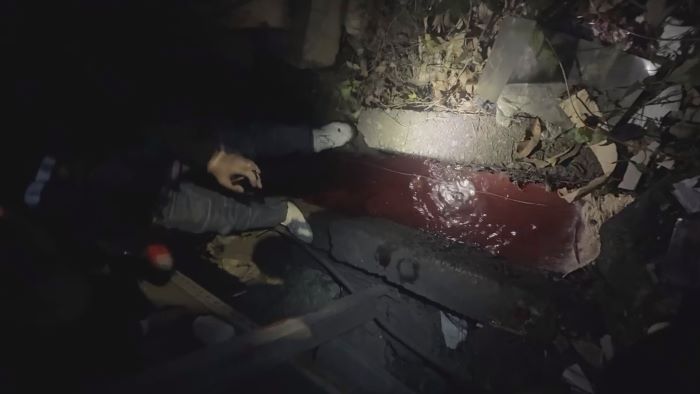 《圖說》稽查人員於泰山區中港南路旁水溝發現紅色廢水。〈環保局提供〉