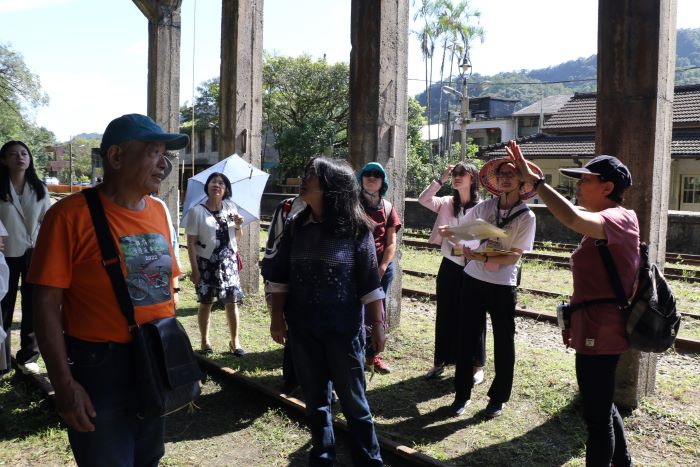 《圖說》礦工的女兒楊桂馨(右1)為遊客解說卸煤櫃的運作。〈社會局提供〉