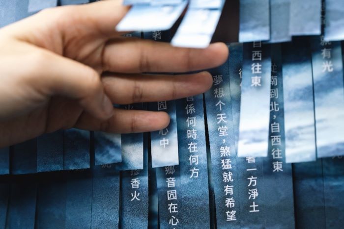 《圖說》新北市立圖書館總館的客家閱讀專區,以剪紙層次堆疊出起伏波濤的「剪紙堆疊詩牆」,使並呈現客籍詩人王興寶的作品《夢想个天堂》。〈客家局提供〉